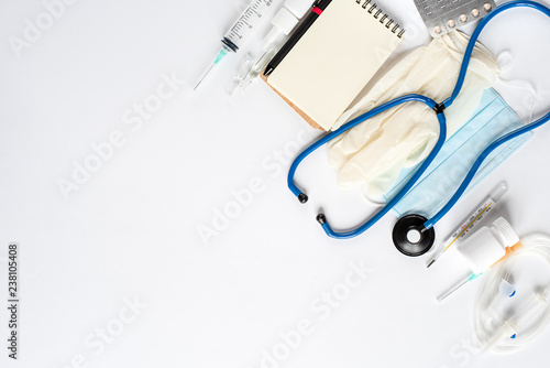 Various medical equipment and Notepad on white background. The view from the top.