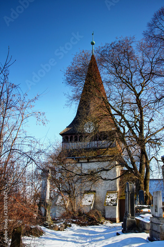 Bell tower of Gothic Protestant Church of Avas an old historical building and symbol of city of Miskolc in sunny winter day from snow-covered Avas cemetery, Northern Hungary Central / Eastern Europe photo