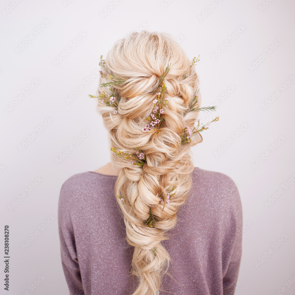 Back view of an elegant trendy hairstyle, interlacing curls and decorating with flower petals - obrazy, fototapety, plakaty 