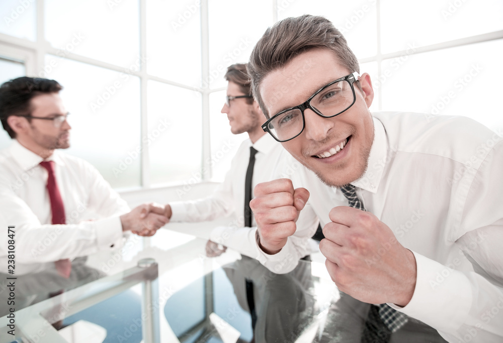 smiling young businessman sitting in office smiling young businessman sitting in office