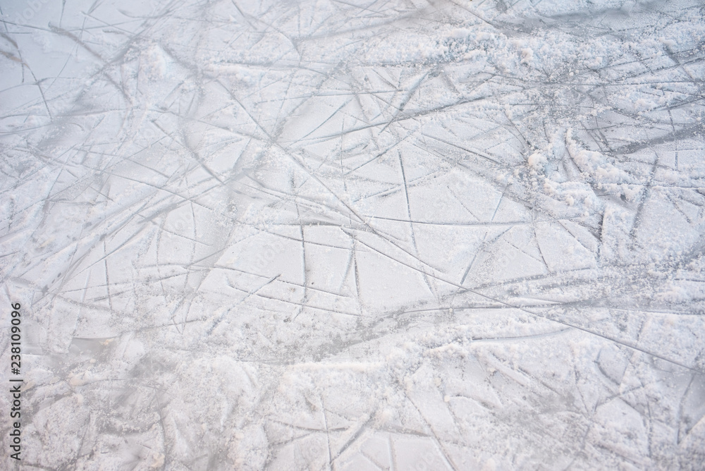 Floor background of a frozen ice rink with skate marks, with white snow during the winter. Floor background of a frozen ice rink with skate marks, with white snow during the winter.