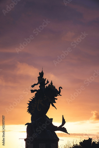 silhouette of a statue of a Balinese deity on the background of a beautiful sunset sky