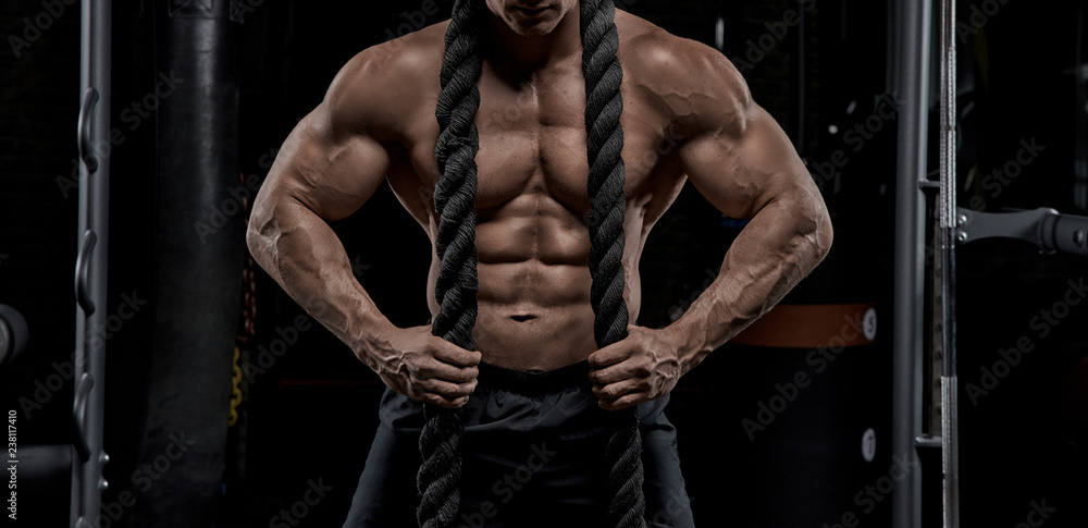 Muscular man working out in gym doing exercises, strong male naked torso abs. Muscular man working out in gym doing exercises, strong male naked torso abs.