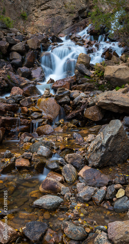 Cascade falls and rocks in mountain stream