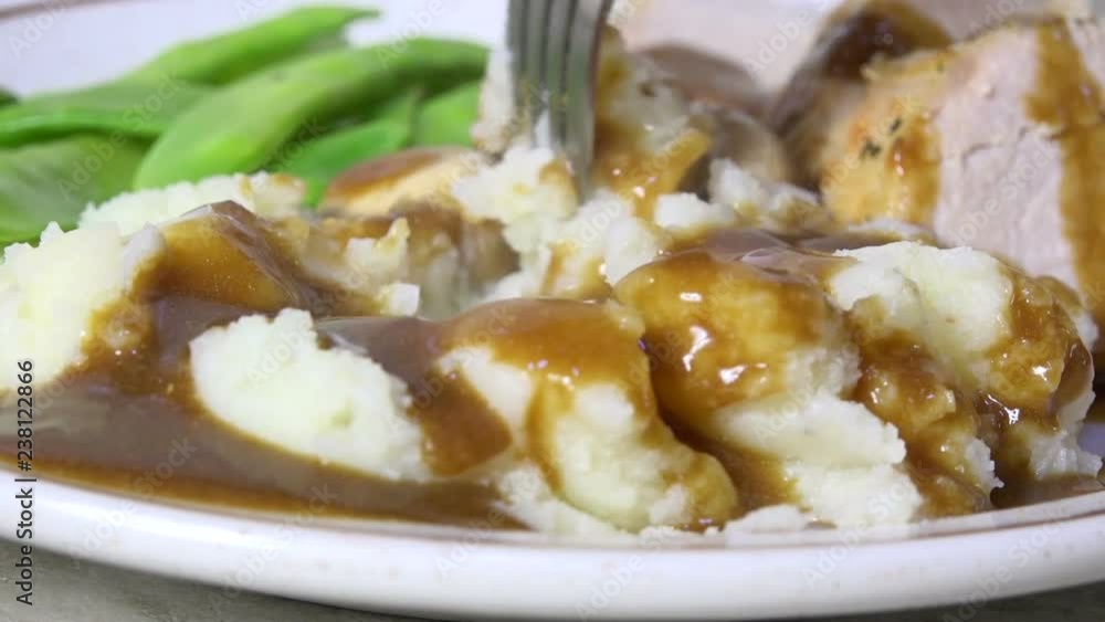 Taking a forkful of mashed potatoes and gravy, close up, slow motion Taking a forkful of mashed potatoes and gravy, close up, slow motion