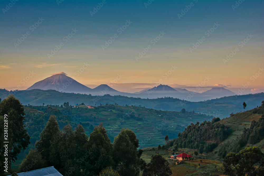 Uganda volcanoes with morning clouds and layered colored sky