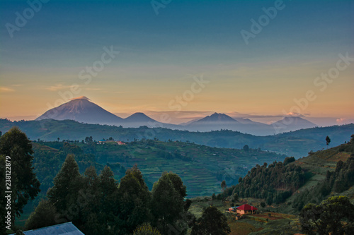 Uganda volcanoes with morning clouds and layered colored sky