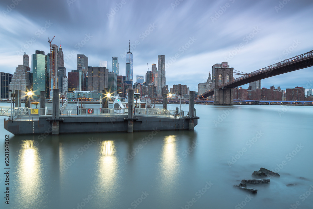 View on east river ferry and Downtown manhattan at sunrise with long exposure