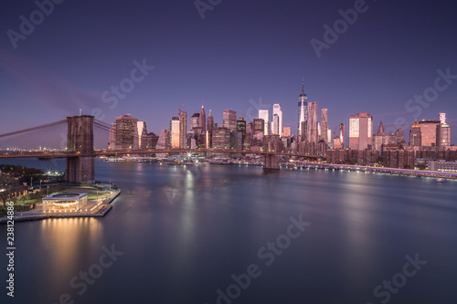 Aerial view on East river with Brooklyn Bridge and financial district at night long exposure