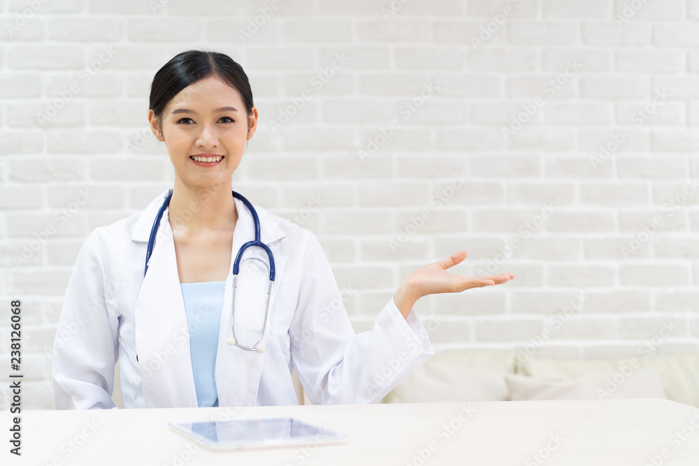 Closeup portrait of smiling beautiful female asian doctor standing with her arms crossed. Medicine representative concept on brick background. Closeup portrait of smiling beautiful female asian doctor standing with her arms crossed. Medicine representative concept on brick background.