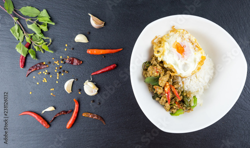 Spicy Thai basil with Crispy Chicken and Egg (Pad Krapow Gai) on table . it is a very delicious Thai food. Rice topped with stir-fried pork and basil leaves . street food in Thailand.