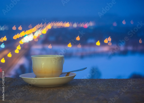 Cup and saucer with blurred colorful background.