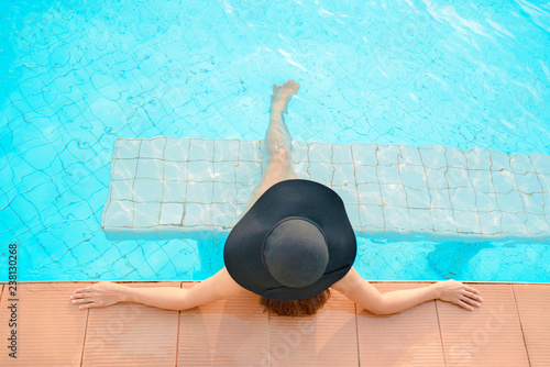 Summer time and Vacations. Women lifestyle relaxing and happy near luxury swimming pool sunbath, summer day at the beach resort in the hotel. Summer Concept photo