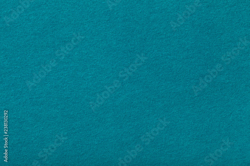 Dark turquoise matt suede fabric closeup. Velvet texture of felt.