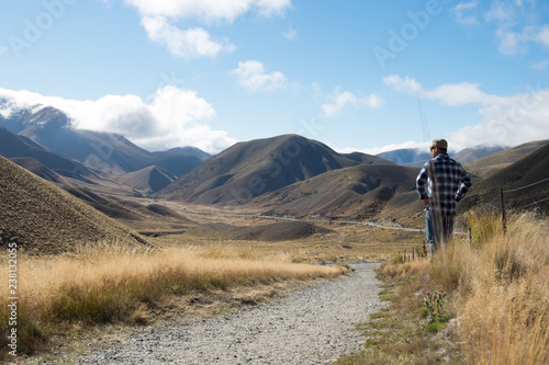 Men standing alone looking at a road through a desert in South Island, New Zealand. © NIPATHORN