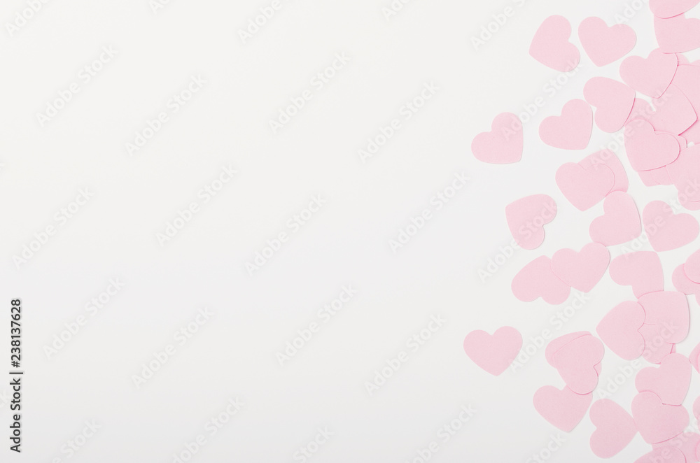 Small pink paper hearts on white background. Place for the inscription, congratulations on Valentine's Day, March 8. Copy space, top view, flat lay
