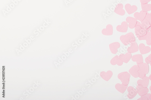 Small pink paper hearts on white background. Place for the inscription, congratulations on Valentine's Day, March 8. Copy space, top view, flat lay