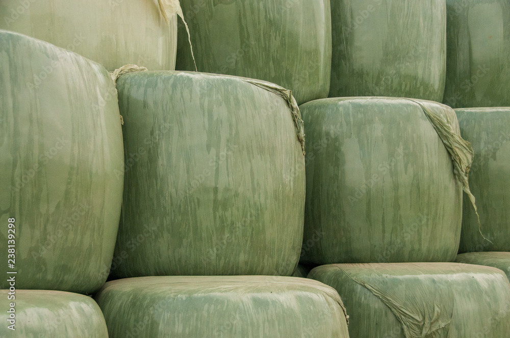 Close-up of a stack of hay-bales being wrapped in Plastic.. East-Flanders in the summer of 2016 Close-up of a stack of hay-bales being wrapped in Plastic.. East-Flanders in the summer of 2016