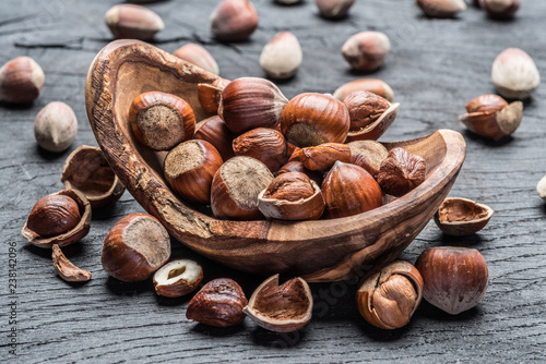 Filberts or hazelnuts in the wooden bowl on the table.