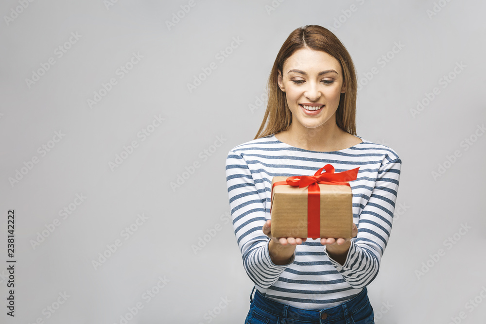 Smiling woman hold gift box isolated over white background. Portrait of a joyful young woman dressed in casual, holding gift box and celebrating. Smiling woman hold gift box isolated over white background. Portrait of a joyful young woman dressed in casual, holding gift box and celebrating.