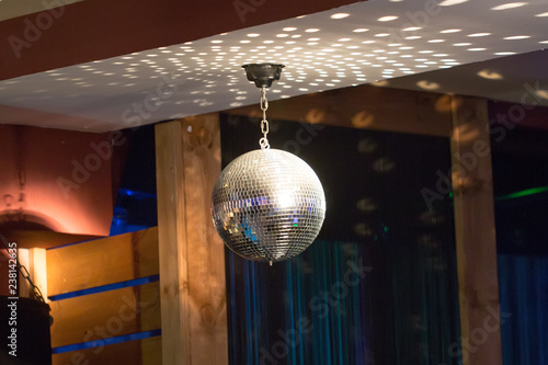 Silver mirror disco ball in the rays of the spotlights photo