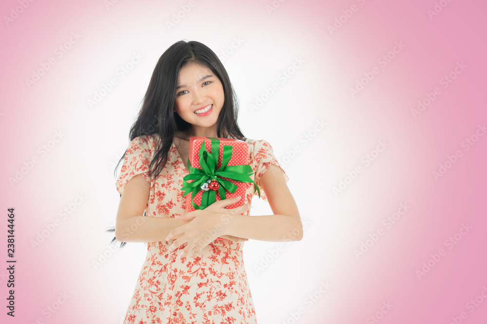 Photo of curious woman in red dress her birthday or new year gift box. Young woman holding gift box with red bow being excited and surprised holiday present isolated white background Photo of curious woman in red dress her birthday or new year gift box. Young woman holding gift box with red bow being excited and surprised holiday present isolated white background