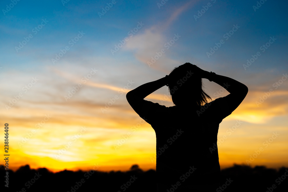 Fototapeta premium Silhouette woman standing sad in the sunset.
