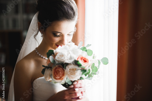 Luxury bride in white dress posing while preparing for the wedding ceremony