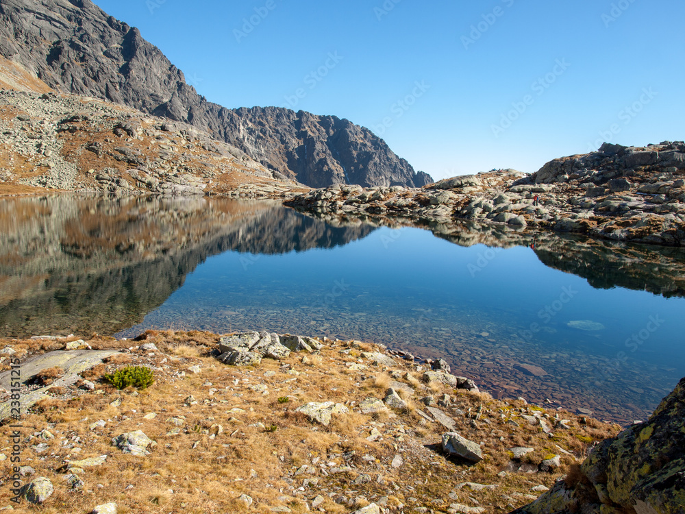 Lake in mountains. Pond in Valley of Five Spis Lakes surrounded by rocky summits, High Tatra Mountains, Slovakia.