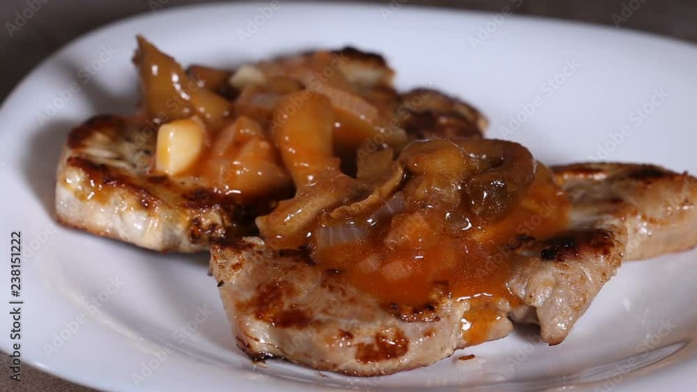 Putting sauce made from tomatoes, mushrooms and other vegetables on fried pork chop Putting sauce made from tomatoes, mushrooms and other vegetables on fried pork chop