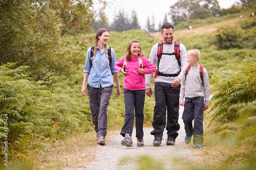 Young family walking on a country path during a family camping holiday