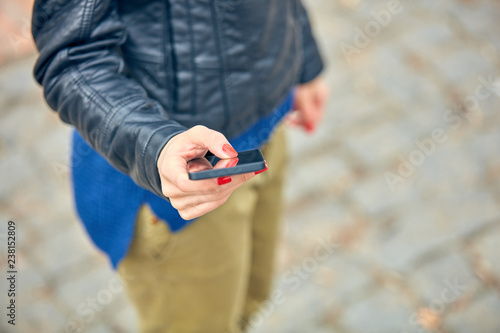 Woman using modern smartphone on the street.