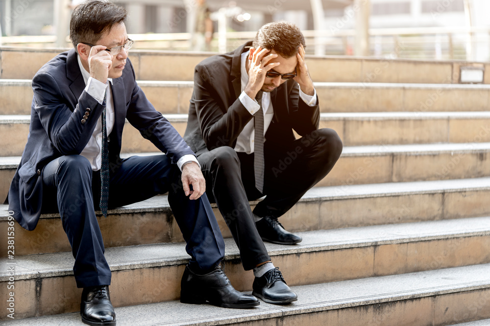 Two middle aged people unemployed businessman stress sitting on stair After experiencing problems despair low economic crisis, concept of Jobless Stressed business failure and unemployment problem. Two middle aged people unemployed businessman stress sitting on stair After experiencing problems despair low economic crisis, concept of Jobless Stressed business failure and unemployment problem.