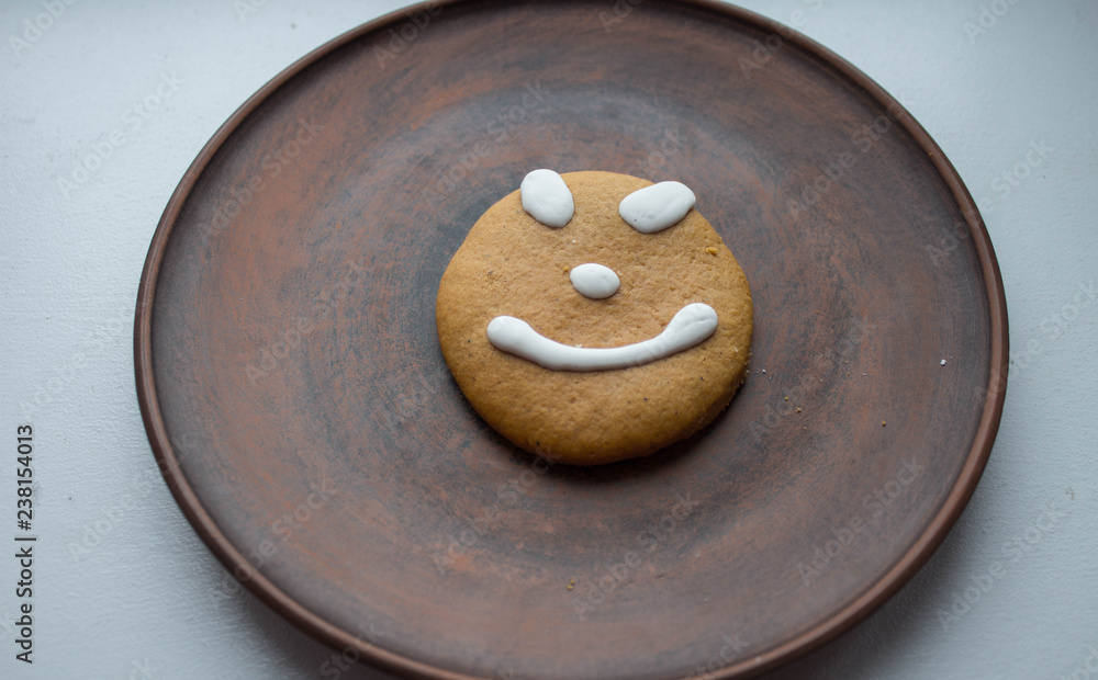 a gingerbread cookie with a smile on a plate
