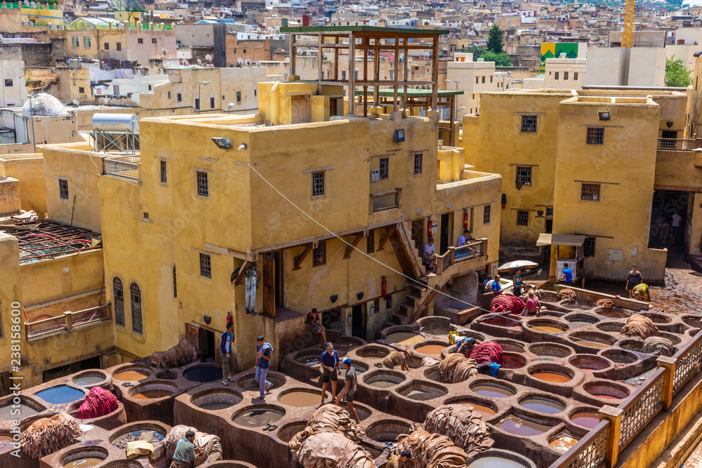 FEZ, MOROCCO, 15 AUGUST 2018: Men working in the traditional and famous tanneries of the medina FEZ, MOROCCO, 15 AUGUST 2018: Men working in the traditional and famous tanneries of the medina
