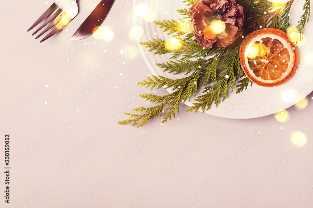 Holiday christmas Plate and cutlery with coniferous twig and dry orange on beige background