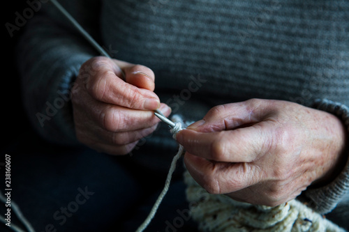 Close up of an older womens hands knitting a jumper photo
