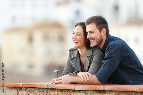 Happy couple enjoying views in a terrace on vacation photo