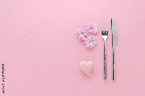 event decoration with cherry flowers, hearth,knife and fork set on pink
