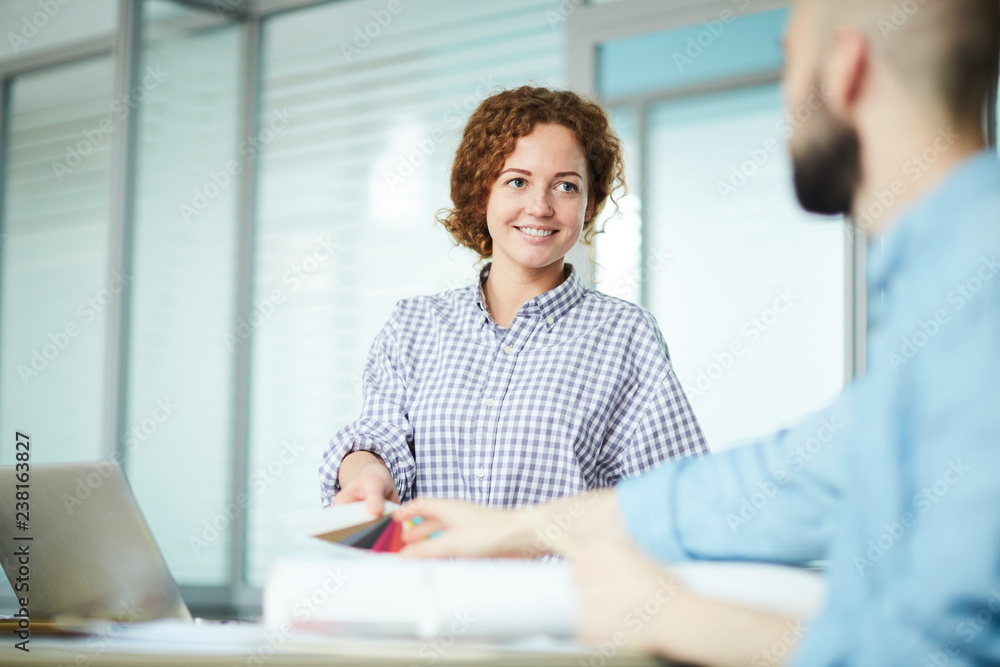 Φωτογραφία Positive attractive redhead lady in casual shirt giving color swatch to colleagu