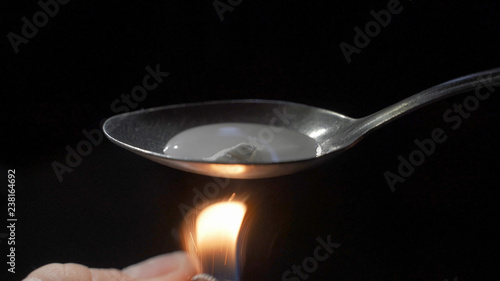 Foto addict heating heroin in a spoon over a flame