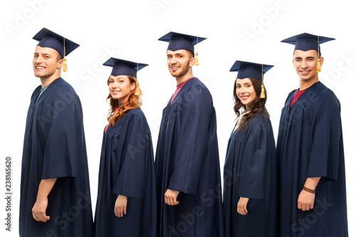 education, graduation and people concept - group of happy graduate students in mortar boards and bachelor gowns over white background
