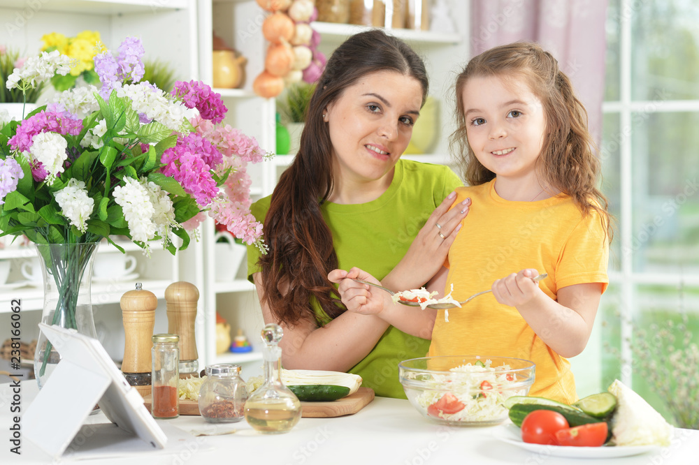 Cute little girl with her mother cooking together Cute little girl with her mother cooking together