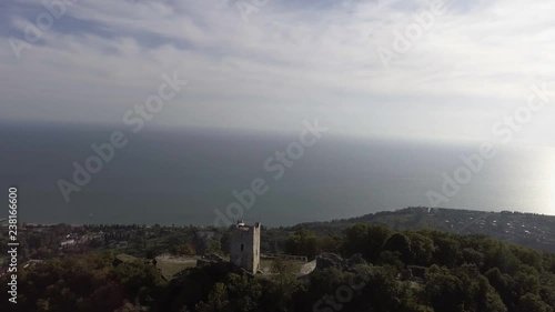 Scenery of beautiful Anacopia Fortress in Abkhazia and amazing Black Sea with long shore coast connecting with valley and green hills on summer sunny day with amazing blue sky. photo