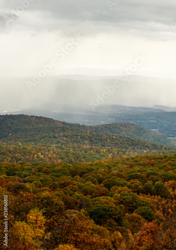 fall color forest and rolling hills and valleys in the Appalachians of Virginia with rain and clouds in the distance