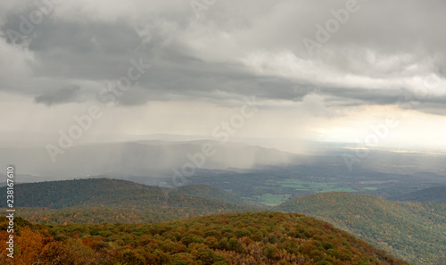 fall color forest and rolling hills and valleys in the Appalachians of Virginia with rain and clouds in the distance