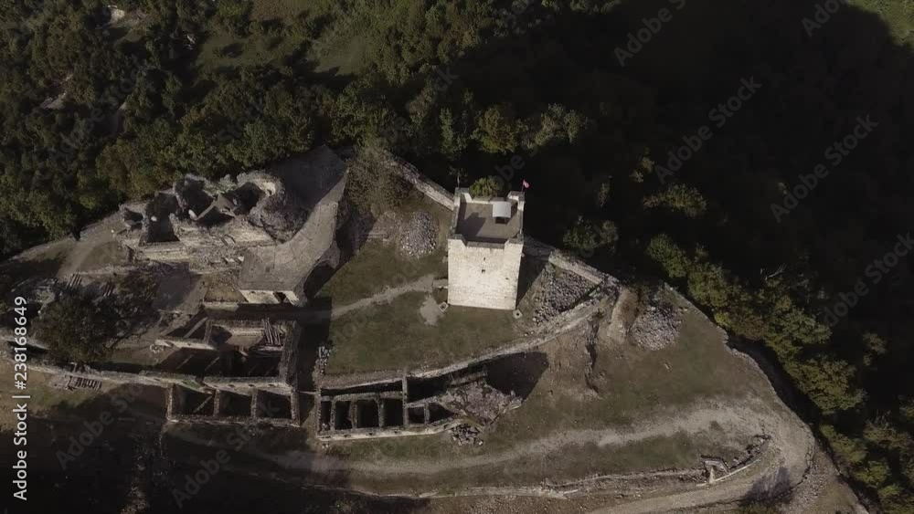 Aerial view of beautiful Anacopia Fortress in Abkhazia surrounded by small valley and green hills on summer sunny day with amazing blue sky. Aerial view of beautiful Anacopia Fortress in Abkhazia surrounded by small valley and green hills on summer sunny day with amazing blue sky.