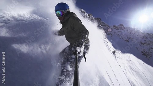 Person snowboarder snowboarding down slope closeup with gopro photo
