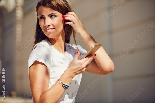 Young attractive woman using cellphone in urban surroundings.