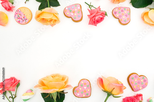 Fototapeta Naklejka Na Ścianę i Meble -  Frame of roses flowers with cookies on white background. Flat lay